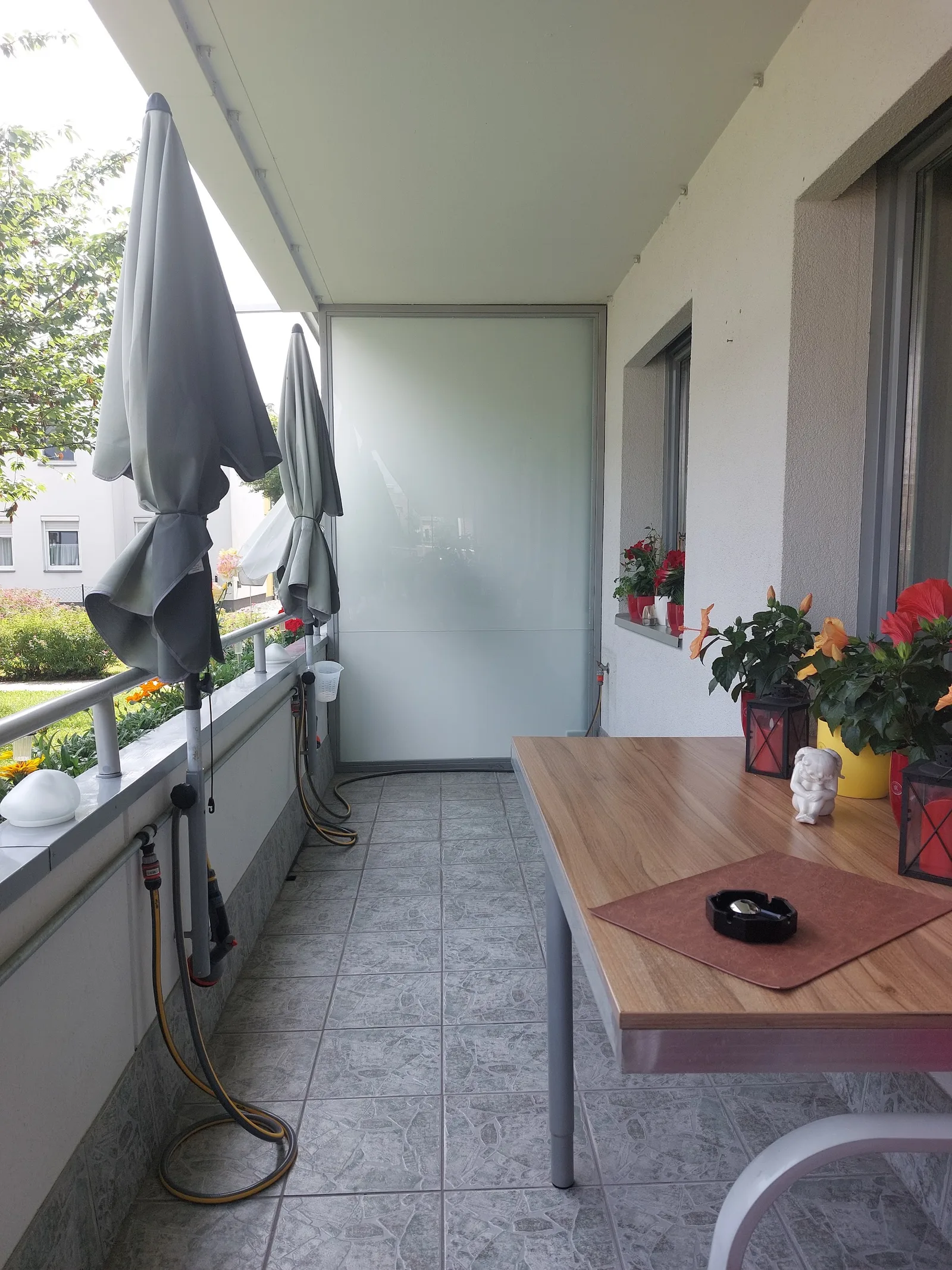 Balkon mit mattem Glaselement als Windschutz an der Stirnseite