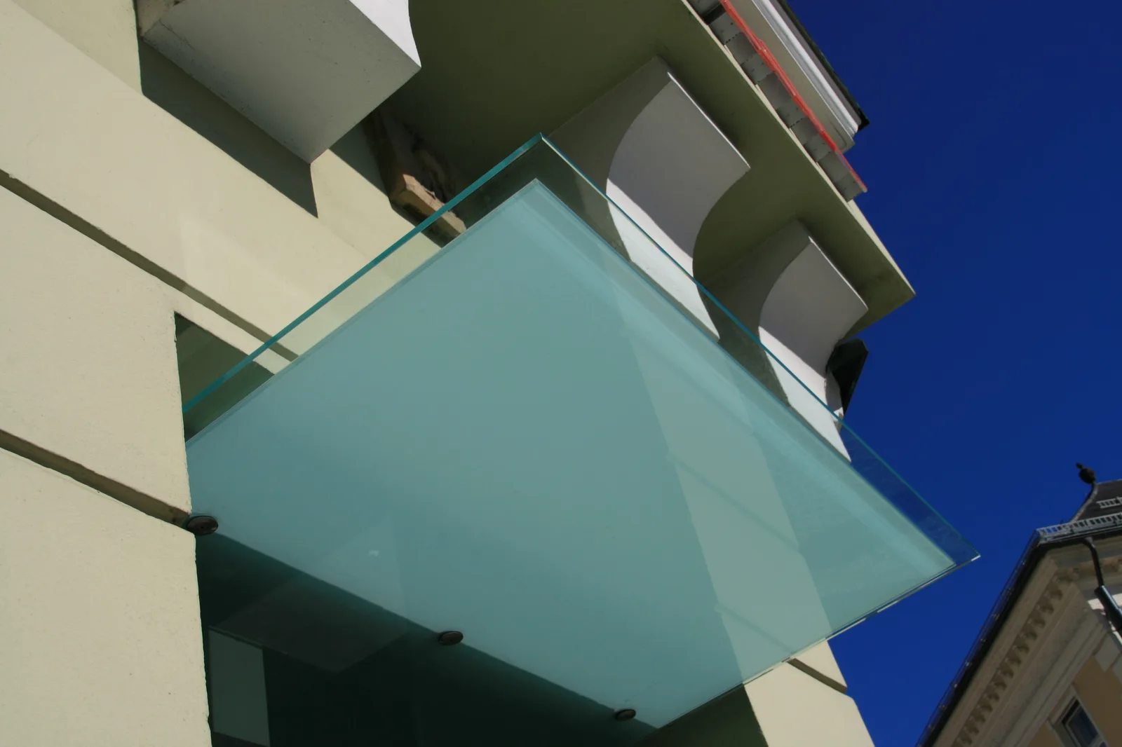 Glasvordach an einer hellen Hausfassade