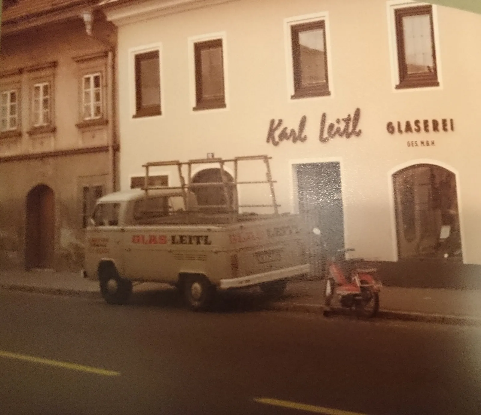 Alte Farbaufnahme des Hauses in der St. Veiter Straße mit Firmenwagen und dem Schriftzug Karl Leitl Glaserei